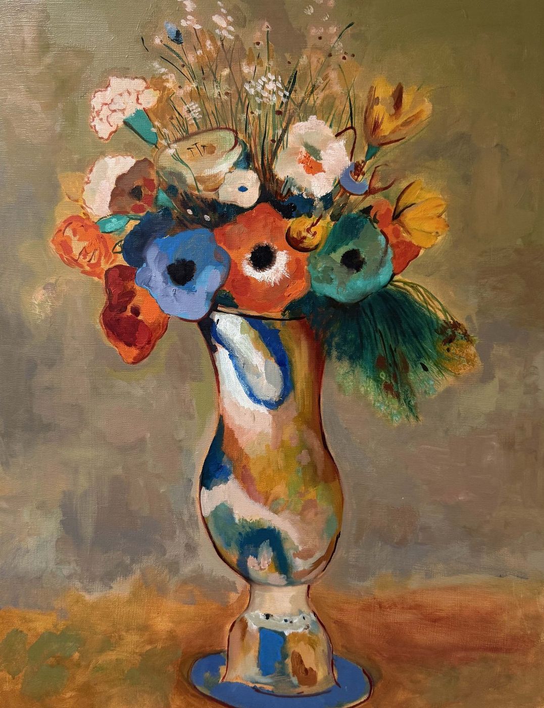 Painting of a bouquet of red, blue and orange flowers with peacock feathers in a mottled tan vase on a blue base.