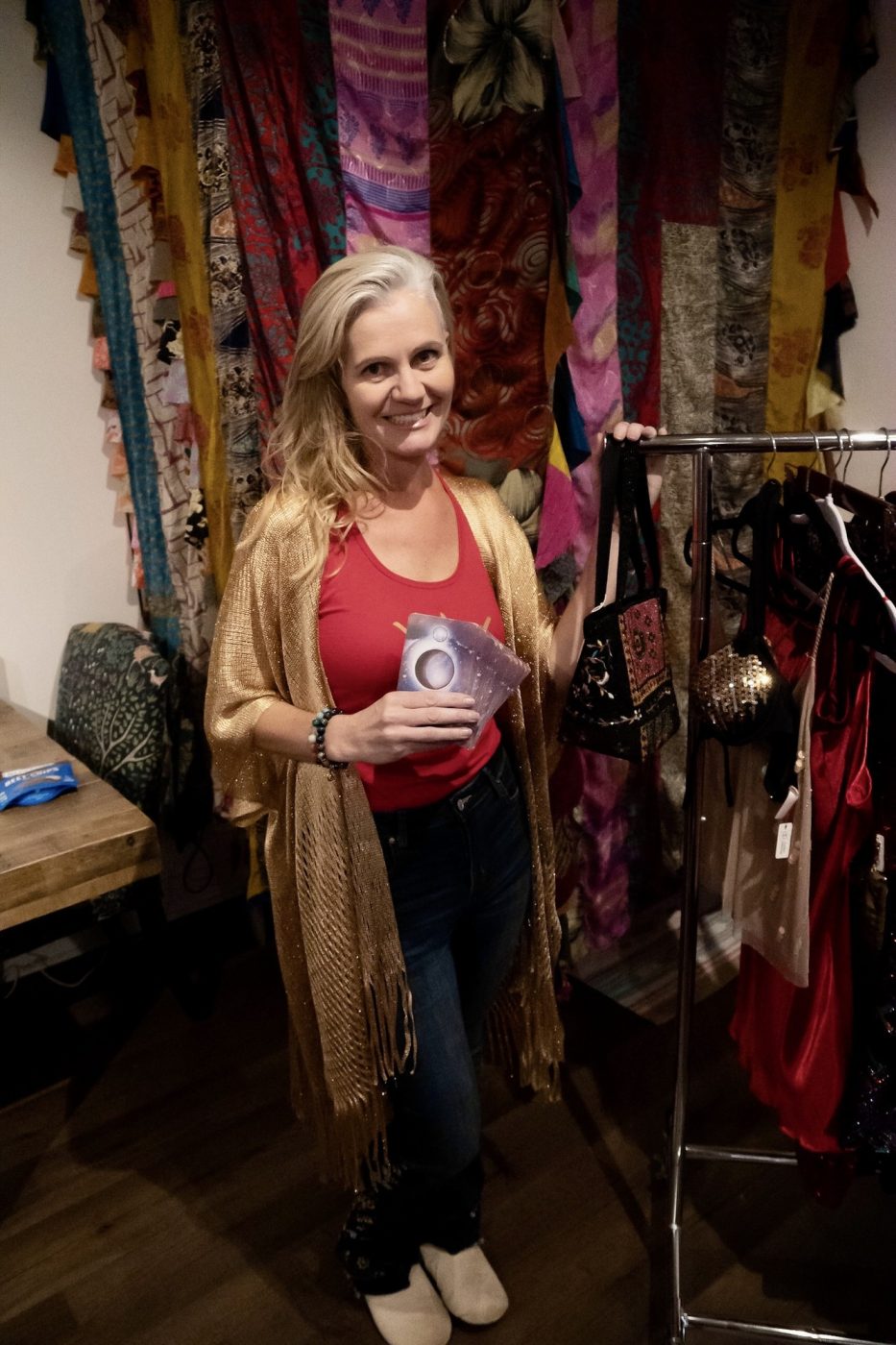 A guest browsing racks of silk scarves and kimonos.