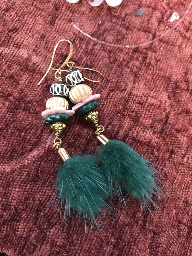 Beaded earrings with green fur tassels.