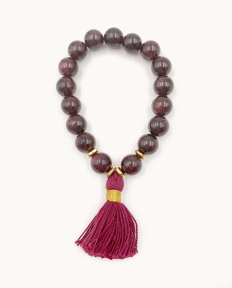 Deep red bead bracelet with a magenta tassel.