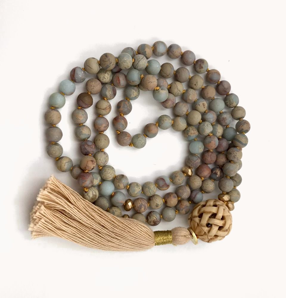 Matte jasper mala with a woven bead and a cream tassel.