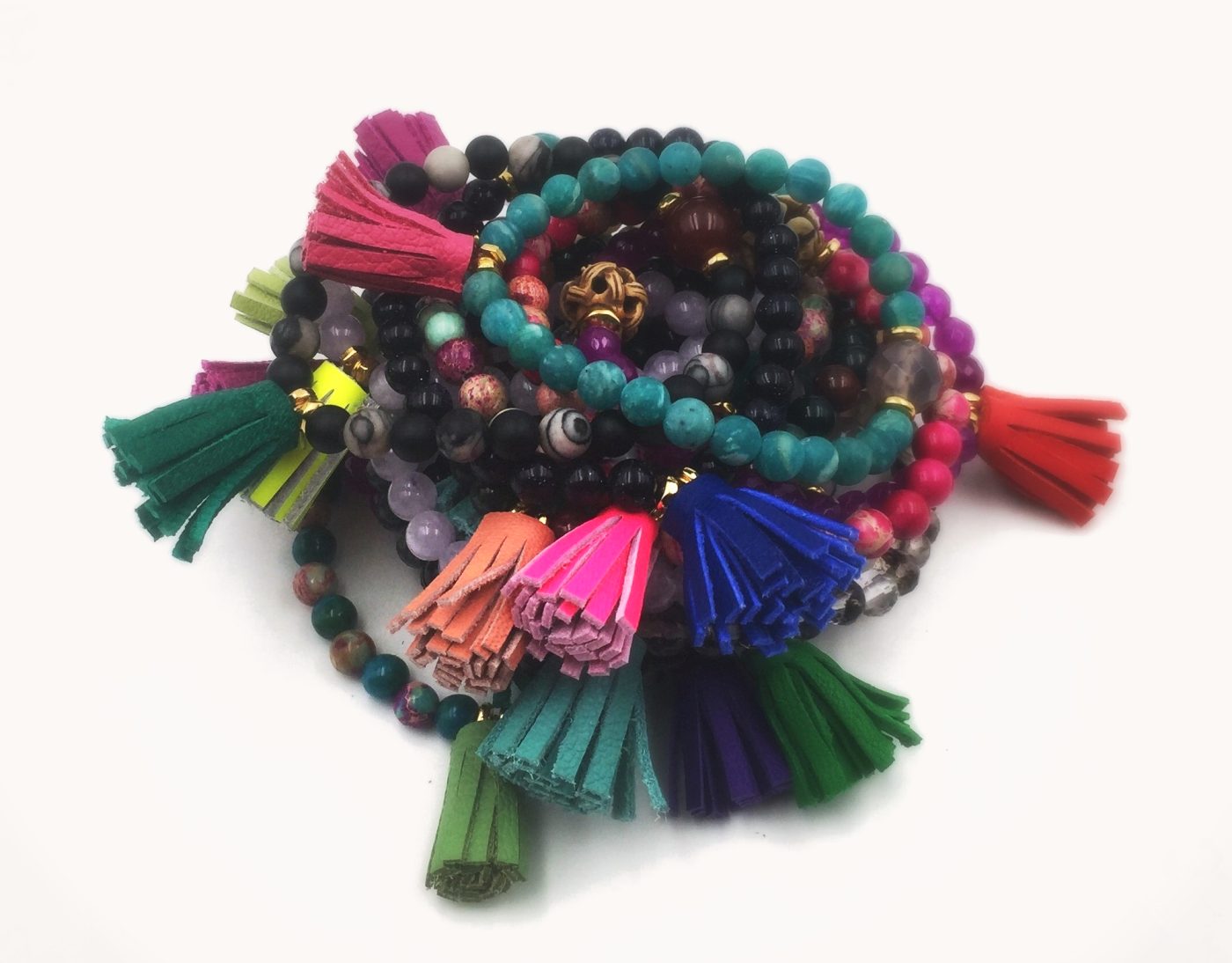 A stack of bracelets with bright suede tassels.