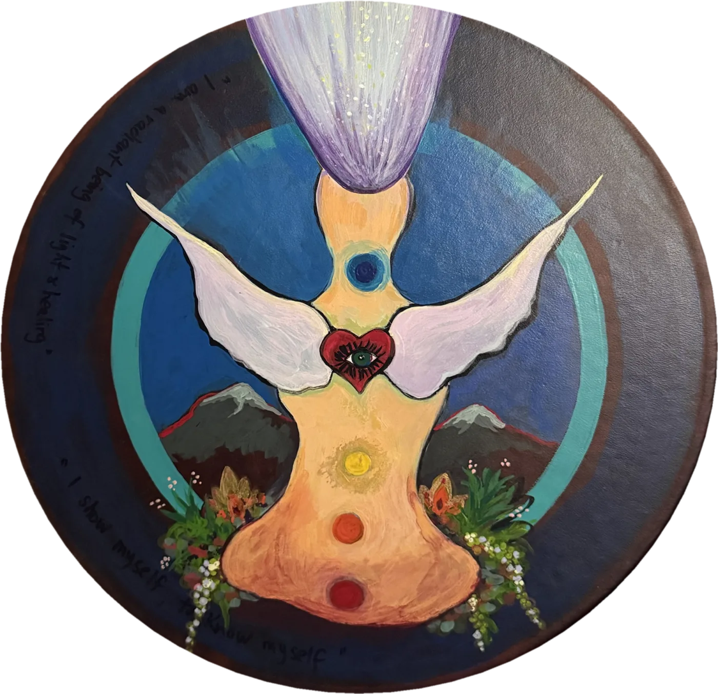 Round painted drum of a winged figure with glowing chakra points and a heart with an eye, between two mountains and flowering plants, hand-lettered “I am a radiant being of light & healing” and “I show myself to know myself,” with a painted tile above.